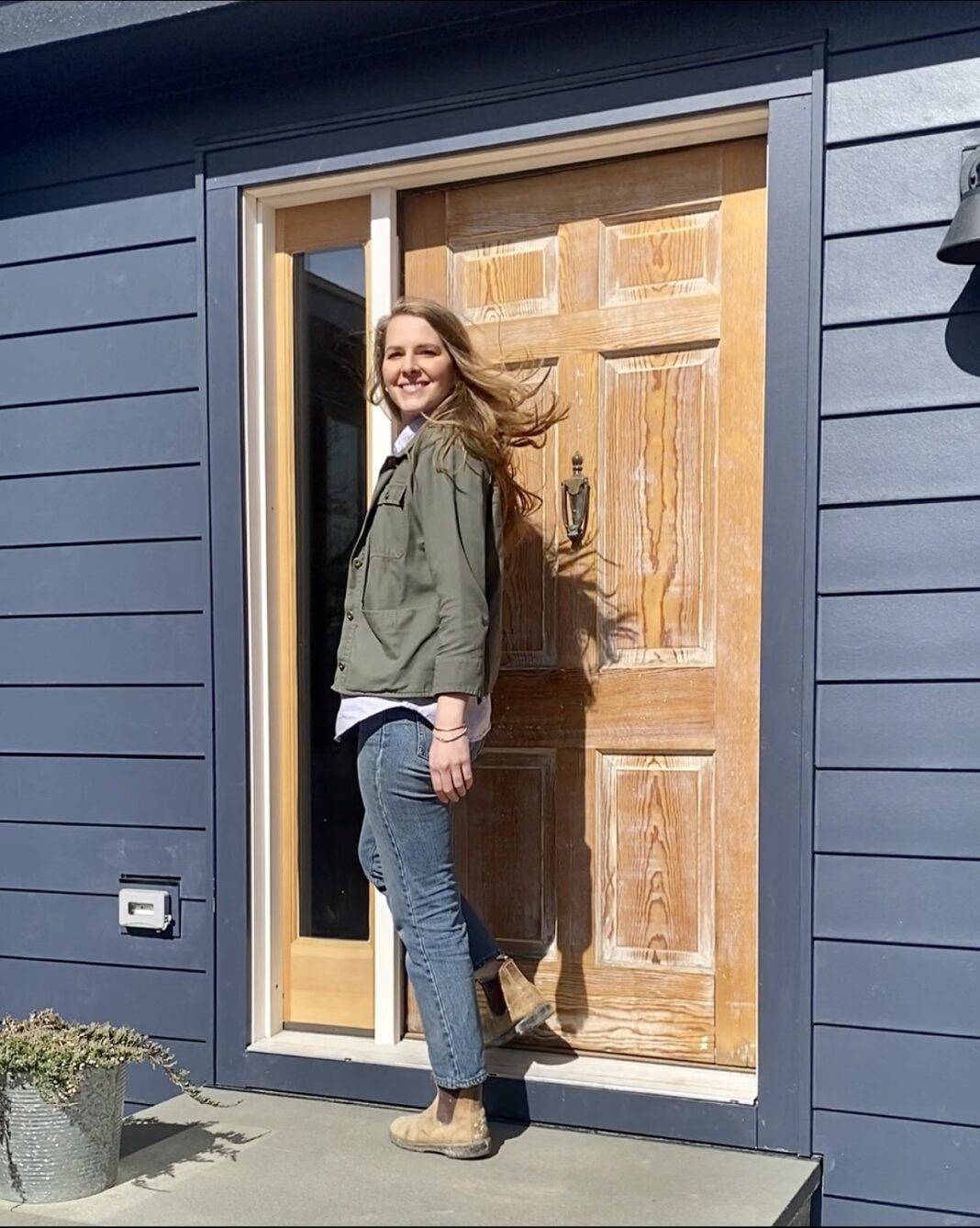 Bea stands at the front door of her newly renovated home.